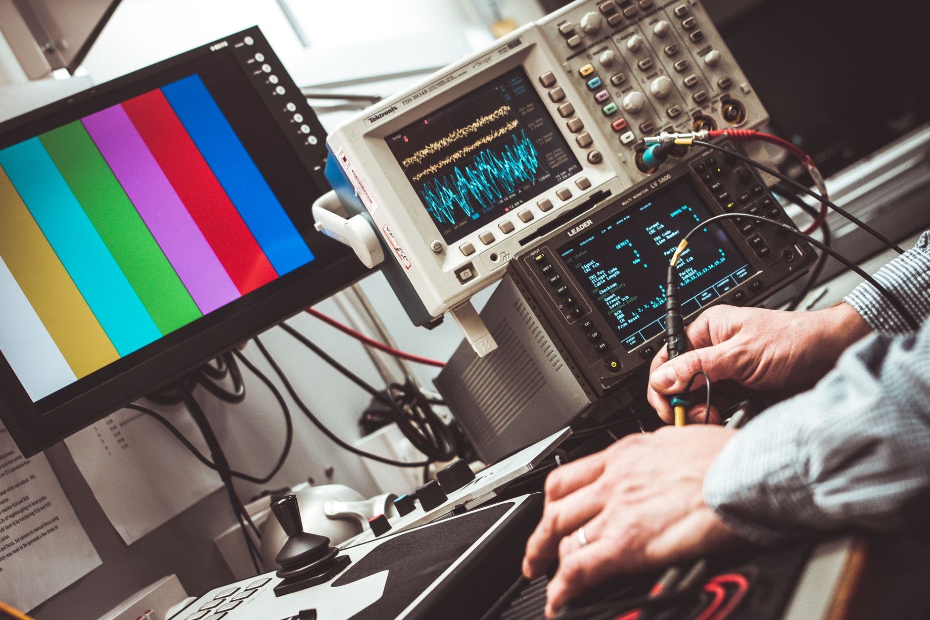 An oscilloscope displaying a waveform on a physics measurement bench