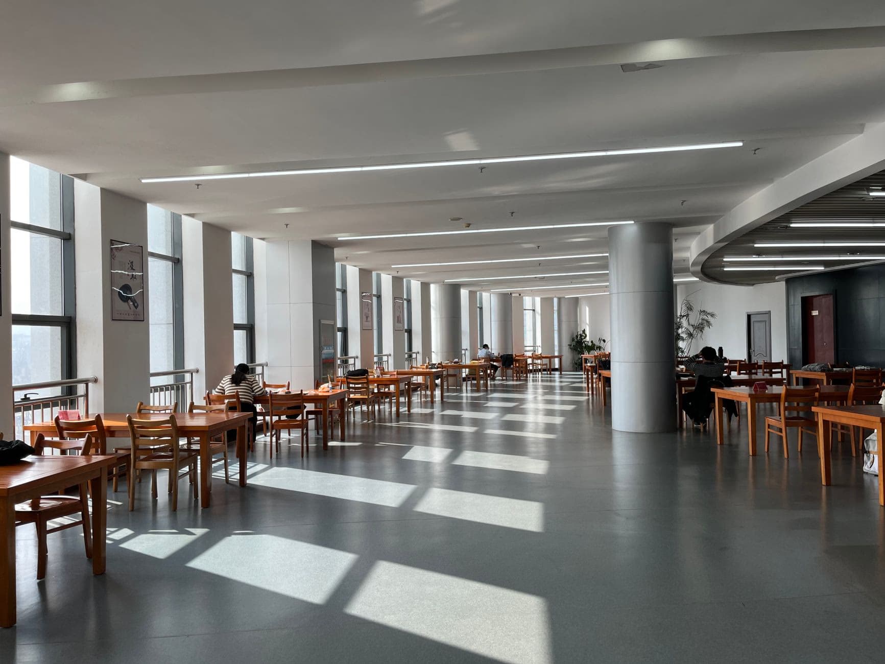 A spacious shared study hall with rows of tables