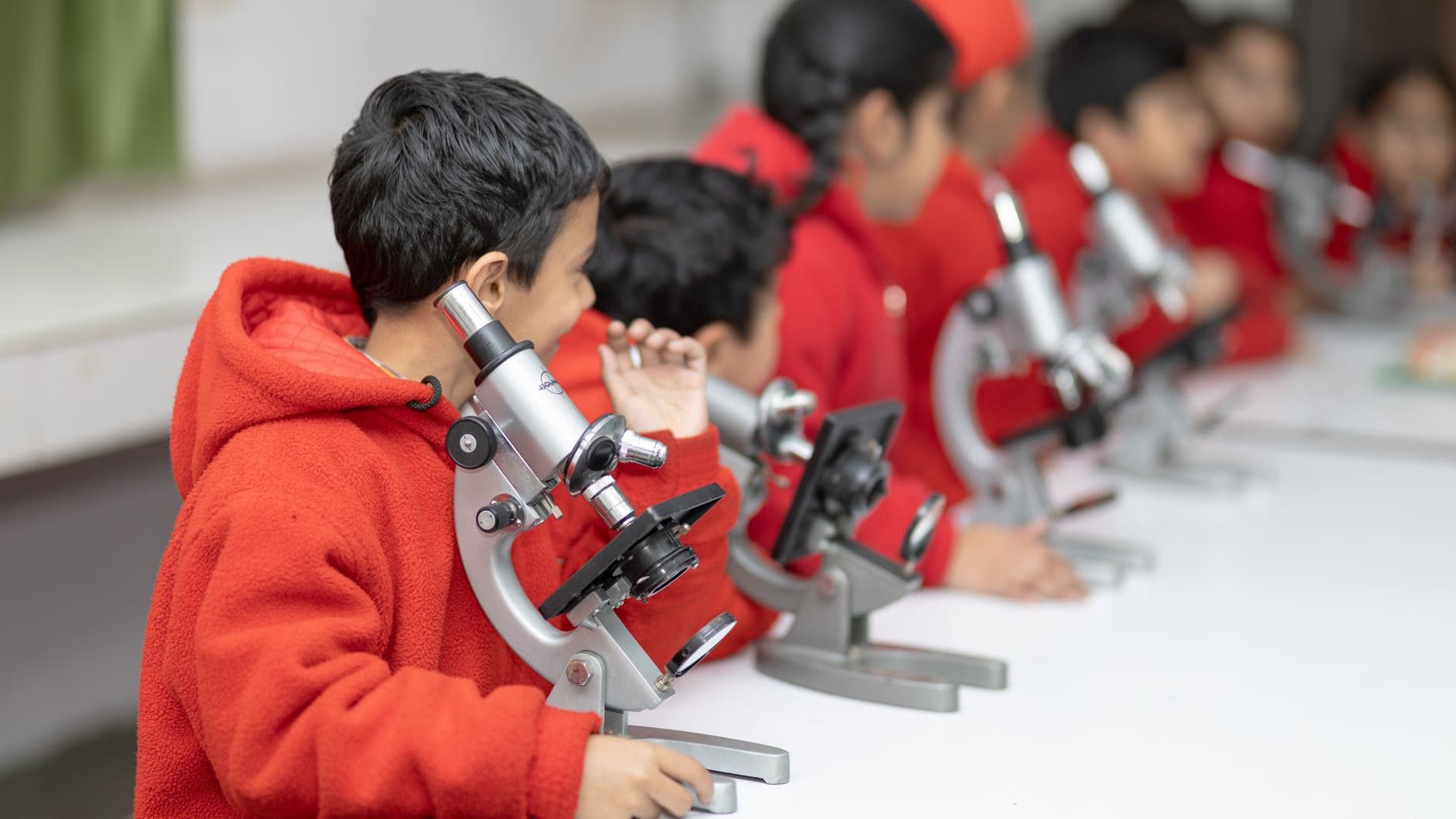 Students using microscopes in a science classroom