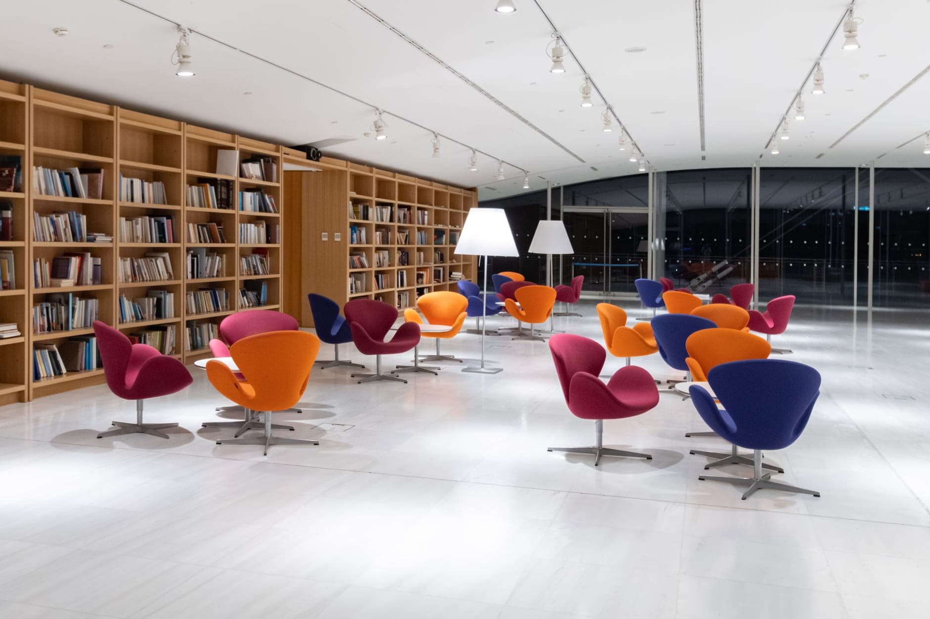 A quiet modern library interior with reading tables and colourful chairs