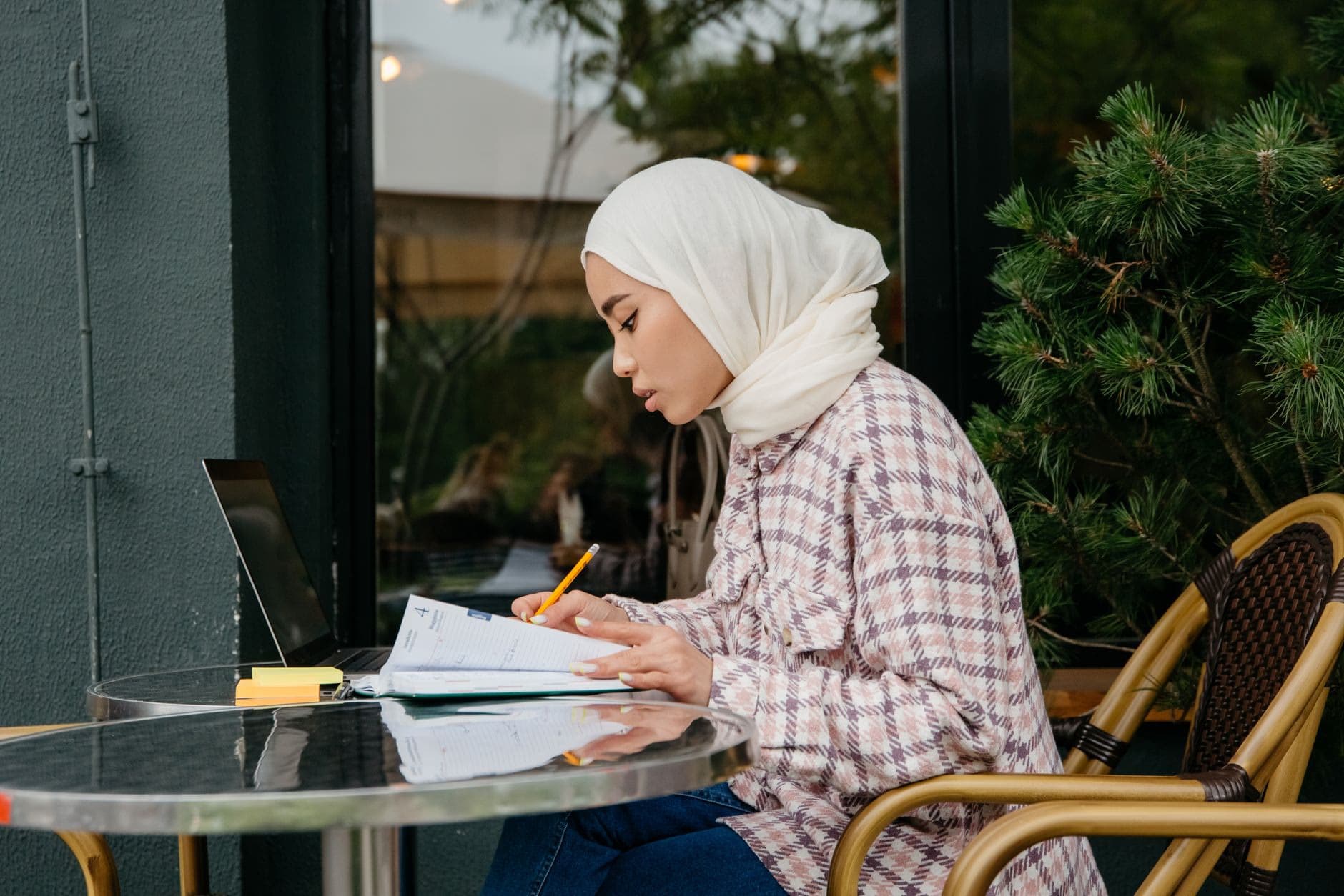 A student working at an outdoor cafe table
