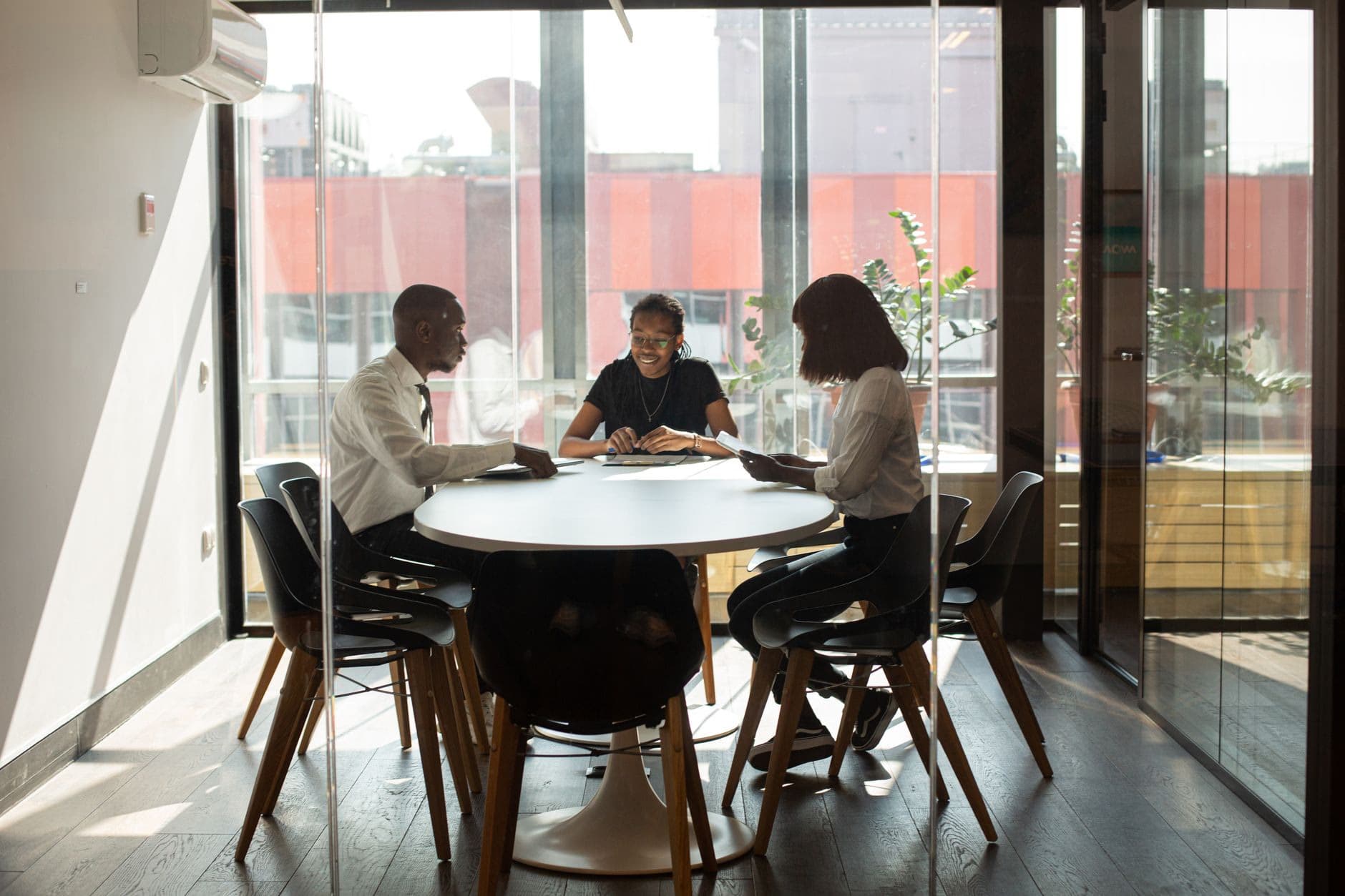 People studying together inside a glass meeting room