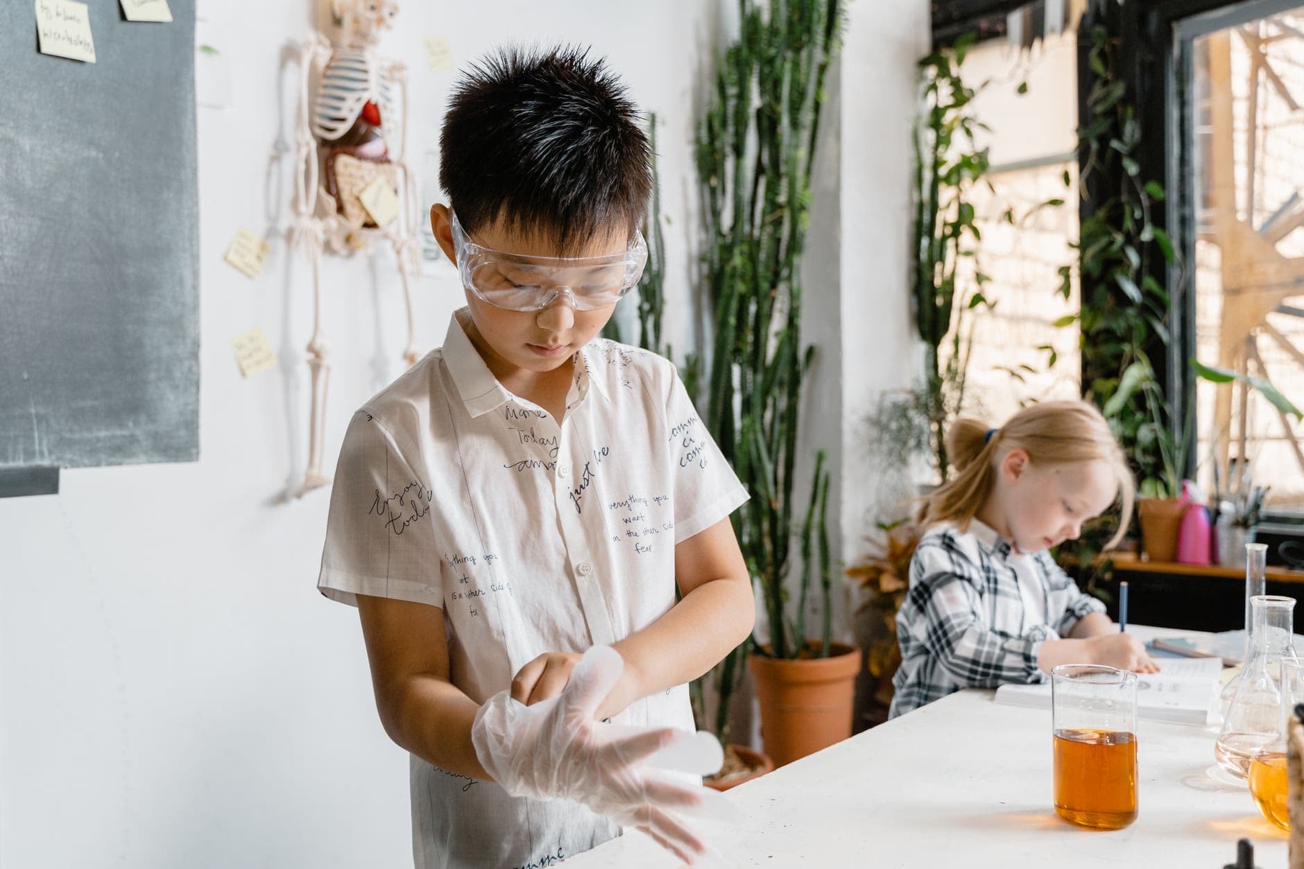 A student putting on protective gloves before a science experiment