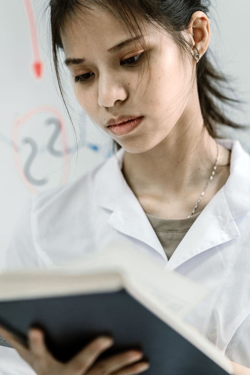 A scientist in protective eyewear reading notes in a laboratory