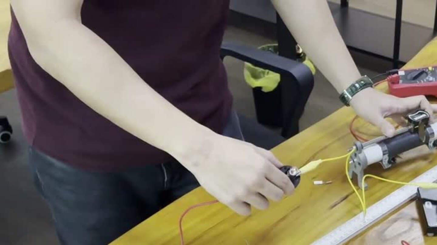 Student hands connecting leads and adjusting an electrical circuit during an Eclat practical session